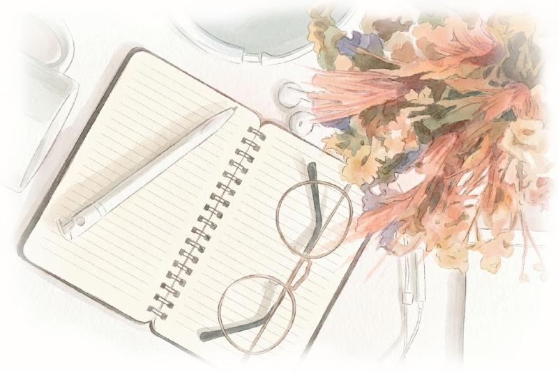 Planner with flowers some glasses on top and a pencil